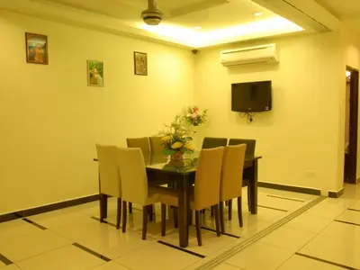 a dining room with a table and chairs and a television at Loong Fatt Hotel in Bidur