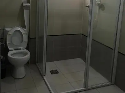 a bathroom with a toilet and a shower stall at Loong Fatt Hotel in Bidur