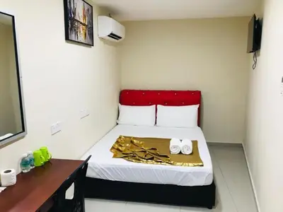 a small room with a bed with a red headboard at GEORGETOWN @ NEW WAVE HOTEL in George Town