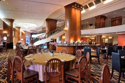 a restaurant with tables and chairs and a bar at Hotel Royal Penang in George Town