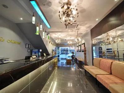 a restaurant with a bar with couches and chandeliers at Le Metrotel in Ipoh