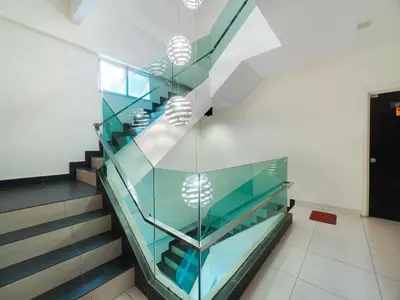 a glass staircase in a building with a black door at GM Holiday Hotel Permai Jaya in Kampong Tebing Rabak