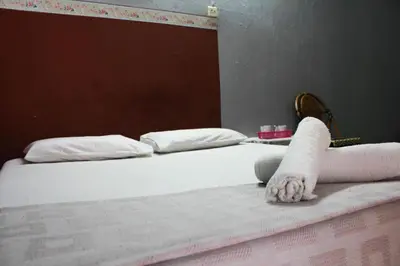 a bed with white sheets and towels on it at Sun Golden Inn in Ipoh