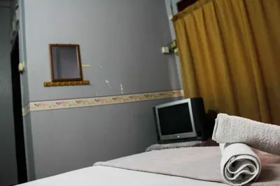 a bedroom with a bed and a computer monitor at Sun Golden Inn in Ipoh