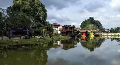 a river with houses and buildings next to a town at Mornington Hotel Soon Choon Ipoh in Kampong Sengat