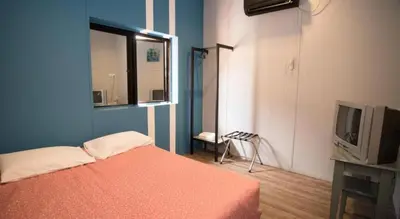 a blue room with a bed and a television at Ipoh Sakura Hotel in Ipoh