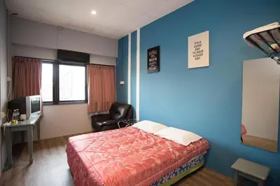 a bedroom with a bed and a blue wall at Ipoh Sakura Hotel in Ipoh