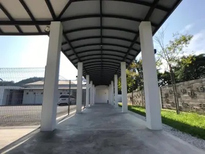 a large building with a roof over a walkway at Kinta Valley Retreat in Kampong Tamboh