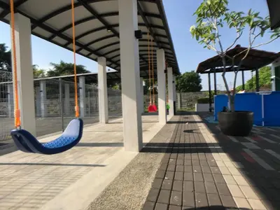 a blue swing hanging from a building with trees at Kinta Valley Retreat in Kampong Tamboh