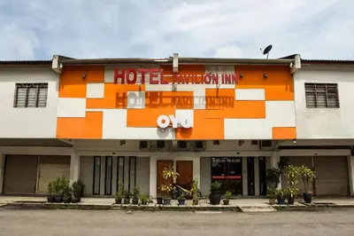 a hotel exterior with an orange and white building at OYO 89454 Hotel Pavilion Inn in Ayer Tawar