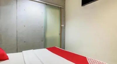 a bedroom with a red and white bed and a mirror at OYO 89454 Hotel Pavilion Inn in Ayer Tawar
