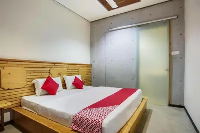a bedroom with a large bed with red pillows at OYO 89454 Hotel Pavilion Inn in Ayer Tawar