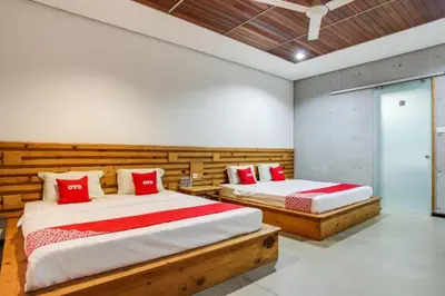 a bedroom with two beds with red pillows at OYO 89454 Hotel Pavilion Inn in Ayer Tawar