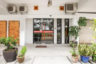 a front door of a building with potted plants at OYO 89454 Hotel Pavilion Inn in Ayer Tawar
