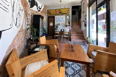 a restaurant with wooden tables and chairs in a room at SPOT ON 90194 Lincoln's Backpacker's in George Town