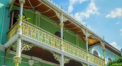 a balcony of a green building with gold railing at SPOT ON 90194 Lincoln's Backpacker's in George Town
