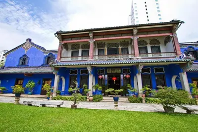 a blue and white house with a green yard at SPOT ON 90194 Lincoln's Backpacker's in George Town