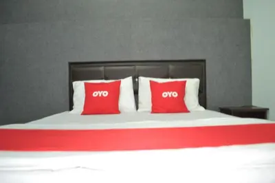 a bed with two red pillows on top of it at OYO 89737 Hotel Tishoa in Kampong Batu Tiga
