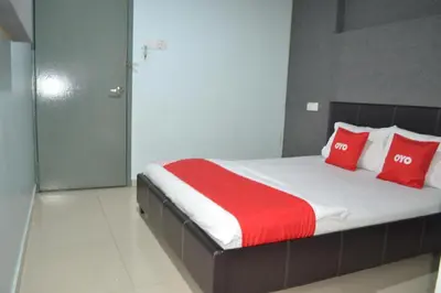 a bedroom with a large bed with red pillows at OYO 89737 Hotel Tishoa in Kampong Batu Tiga