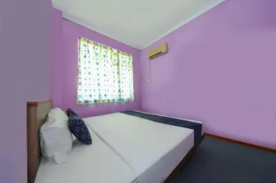 a bedroom with two beds and a window at Capital O 89876 Safari Hotel in Pasir Bogak