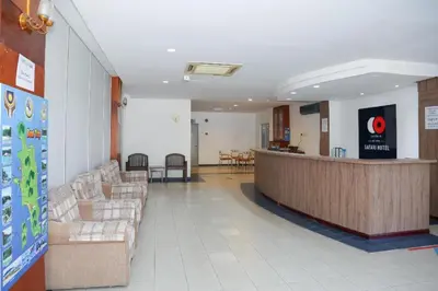 a lobby of a hospital with couches and a bar at Capital O 89876 Safari Hotel in Pasir Bogak