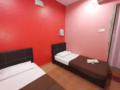 a bedroom with two beds and a red wall at SPOT ON 89865 Hotel Titiwangsa GM in Gua Musang
