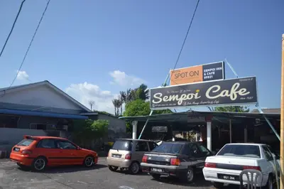 a group of cars parked in front of a cafe at SPOT ON 89821 Batu Maung Sempoi Inn and Cafe in Kampong Batu Maung