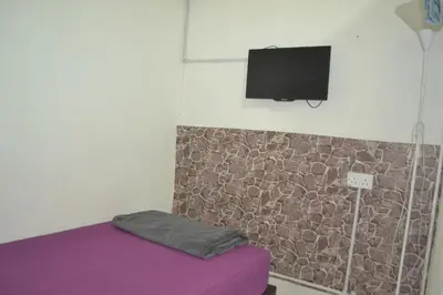 a room with a bed and a tv on a wall at SPOT ON 89821 Batu Maung Sempoi Inn and Cafe in Kampong Batu Maung