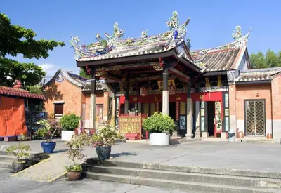 a building with a roof with potted plants in front of it at SPOT ON 89821 Batu Maung Sempoi Inn and Cafe in Kampong Batu Maung