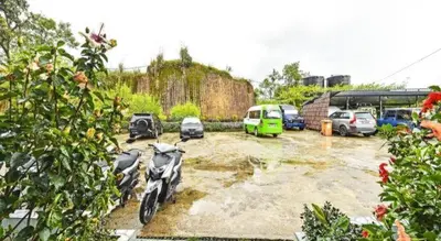 a parking lot with cars and a motorcycle parked at OYO 90722 D'puncak Hotel Cameron Highlands in Cameron Highlands