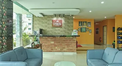 a lobby with two blue chairs and a brick bar at OYO 90722 D'puncak Hotel Cameron Highlands in Cameron Highlands