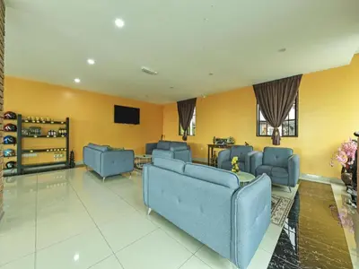 a living room with blue couches and a tv at OYO 90722 D'puncak Hotel Cameron Highlands in Cameron Highlands
