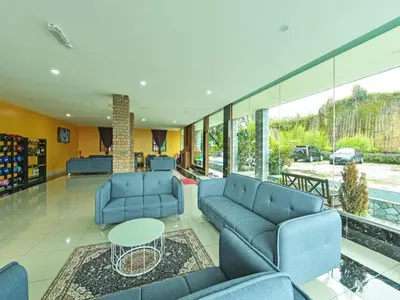 a living room with blue couches and a table at OYO 90722 D'puncak Hotel Cameron Highlands in Cameron Highlands