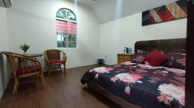 a bedroom with a bed and a table and chairs at OYO Home 90711 9 Roses Villa in Kampong Sahum