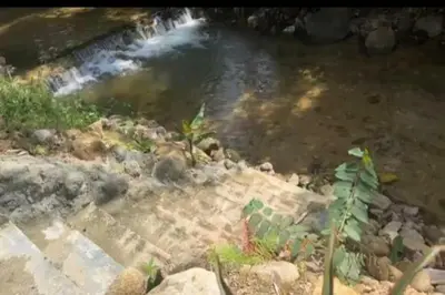 a stream of water with stairs in front of a waterfall at OYO Home 90711 9 Roses Villa in Kampong Sahum
