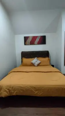 a bedroom with a large bed with yellow sheets and pillows at OYO Home 90711 9 Roses Villa in Kampong Sahum
