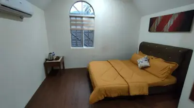 a bedroom with a bed with a yellow blanket at OYO Home 90711 9 Roses Villa in Kampong Sahum