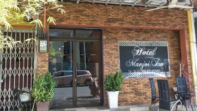a store with a sign on the front of a brick building at OYO 90936 Hotel Manjoi Inn Ipoh in Jelapang