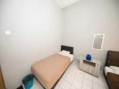 a small bedroom with a bed and a table at Hotel O Iman Roomstay Gua Musang in Kampong Keriting