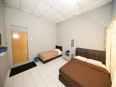 a bedroom with two beds in a room at Hotel O Iman Roomstay Gua Musang in Kampong Keriting