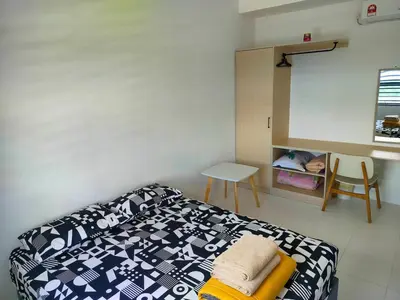 a bedroom with a bed and a table and a desk at IFS SoHo Basic Homestay Entire Home in Seri Iskandar