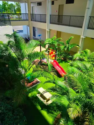 a red truck in a courtyard with palm trees at IFS SoHo Basic Homestay Entire Home in Seri Iskandar