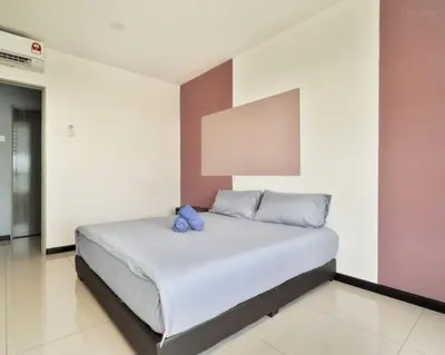a bedroom with a bed with blue pillows on it at 3 Bedroom Izz Homestay Casa kayangan in Ipoh