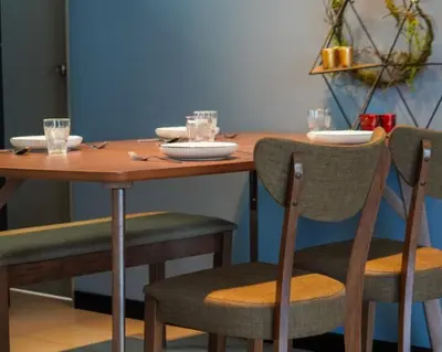 a wooden table and chairs with plates and glasses on it at 3 Bedroom Izz Homestay Casa kayangan in Ipoh