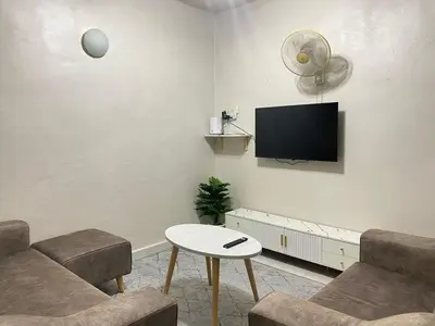 a living room with a couch and a tv on the wall at Imtiyaz Islamic Homestay in Kulim