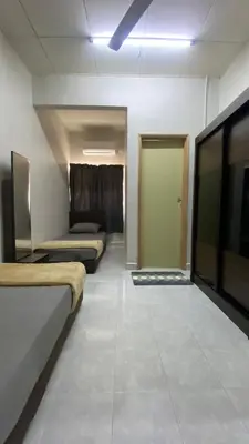 a room with three beds and a hallway with a door at Imtiyaz Islamic Homestay in Kulim