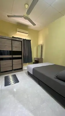 a bedroom with a bed and a ceiling fan at Imtiyaz Islamic Homestay in Kulim