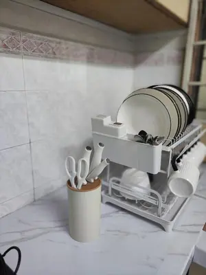 a kitchen counter with a shelf with plates and utensils at Imtiyaz Islamic Homestay in Kulim