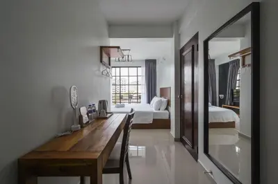 a room with a desk and a bedroom with two beds at Cameron Highland Retreat in Tanah Rata