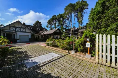 a white fence in front of a house at Cameron Highland Retreat in Tanah Rata
